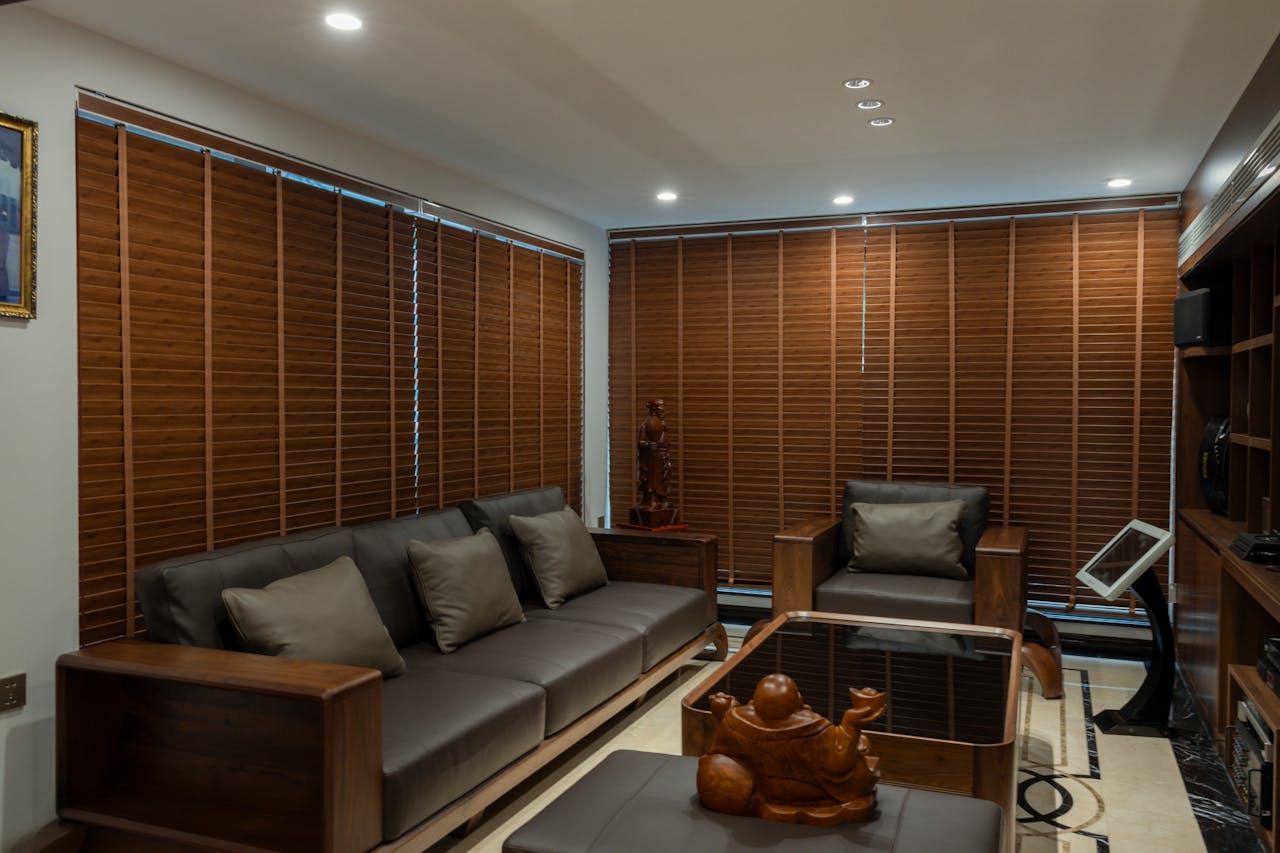 Elegant living room showcasing modern furniture with wooden blinds and cozy decor.