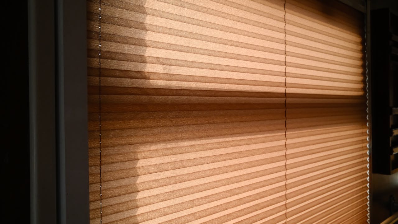 Sunlight streaming through blinds creating warm shadows in a room.